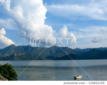 Enjoying a Serene Boat Ride on Skadar Lake, Surrounded by Breathtaking Mountains Enjoying a Serene Boat Ride on Skadar Lake, Surrounded by Breathtaking Mountains 129602299