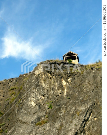 A Charming House Rests Dramatically on a Rocky Cliff, Offering Stunning Views of Skadar Lake 129602302