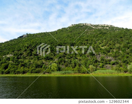 Discover the Serene Beauty of Skadar Lake, Embraced by Lush Mountains and Greenery 129602344