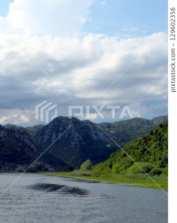 Experience the Breathtaking Beauty of Skadar Lake and Its Stunning Mountain Backdrop in Montenegro 129602356