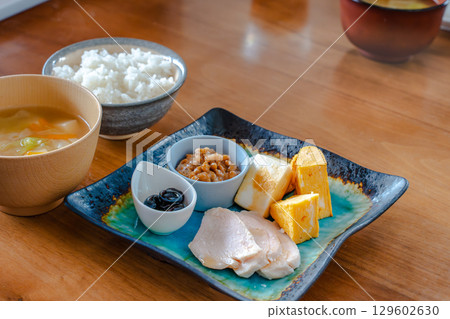 A healthy Japanese-style breakfast set featuring tamagoyaki (rolled omelet), natto, chicken ham, and more A healthy Japanese-style breakfast set featuring tamagoyaki (rolled omelet), natto, chicken ham, and more 129602630