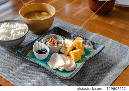 A healthy Japanese-style breakfast set featuring tamagoyaki (rolled omelet), natto, chicken ham, and more A healthy Japanese-style breakfast set featuring tamagoyaki (rolled omelet), natto, chicken ham, and more 129602632