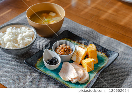 A healthy Japanese-style breakfast set featuring tamagoyaki (rolled omelet), natto, chicken ham, and more A healthy Japanese-style breakfast set featuring tamagoyaki (rolled omelet), natto, chicken ham, and more 129602634