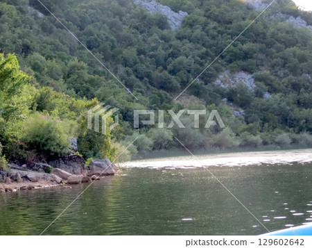 Tranquil Moments by Skadar Lake in Montenegro Surrounded by Lush Greenery and Gentle Ripples Tranquil Moments by Skadar Lake in Montenegro Surrounded by Lush Greenery and Gentle Ripples 129602642