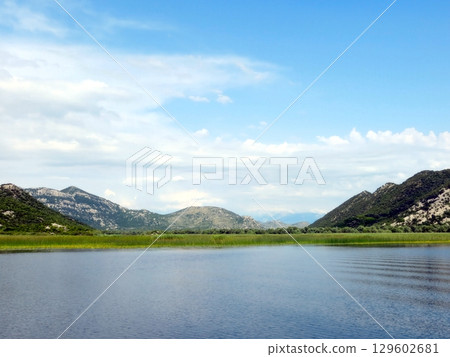 Stunning Reflections of Nature at Skadar Lake in Montenegro Under a Clear Blue Sky 129602681