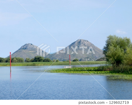 Exploring the Serene Beauty of Skadar Lake in Montenegro With Stunning Mountain Backdrops Exploring the Serene Beauty of Skadar Lake in Montenegro With Stunning Mountain Backdrops 129602719