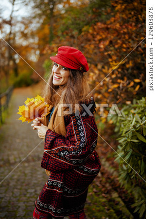 happy modern woman in red hat walking 129603878