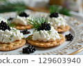 Gourmet Cracker Appetizer with Black Caviar and Cream Cheese on Elegant Plate 129603940