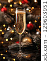 Festive Champagne Glass with Holiday Decor and Bokeh Lights in Background 129603951