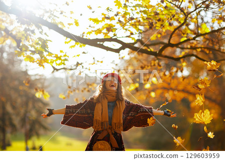 smiling modern woman in red hat with scarf rejoicing smiling modern woman in red hat with scarf rejoicing 129603959