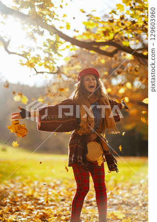 happy modern female in red hat with scarf and gloves rejoicing happy modern female in red hat with scarf and gloves rejoicing 129603960