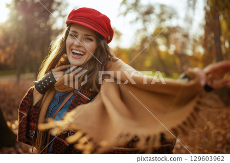 smiling modern woman in red hat with scarf and gloves 129603962