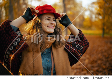 happy elegant woman in red hat with scarf and gloves 129603963