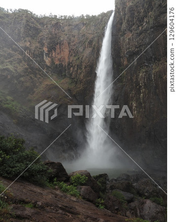 A distant view of Wallaman Falls - the basin of the waterfall submerged in mist A distant view of Wallaman Falls - the basin of the waterfall submerged in mist 129604176