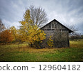 Old wooden house in autumn forest. Log cabin in a forest in the fall. Autumn golden forest 129604182