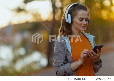 trendy 40 years old woman in fitness clothes in park 129604262