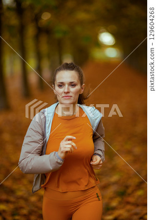 trendy woman in fitness clothes in park running trendy woman in fitness clothes in park running 129604268