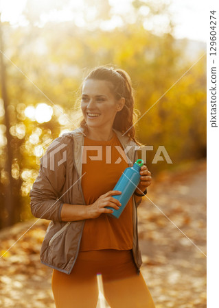 happy elegant woman in fitness clothes in park happy elegant woman in fitness clothes in park 129604274