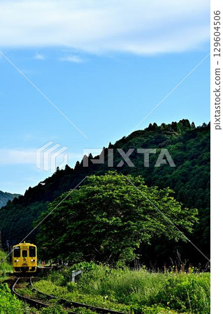 一輛黃色列車駛過築肥線駒成站 129604506