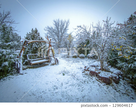Old country cottage courtyard with a large bench, swing. Large bench swing in garden in winter 129604617