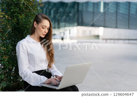 Focused businesswoman with long brown hair working 129604647