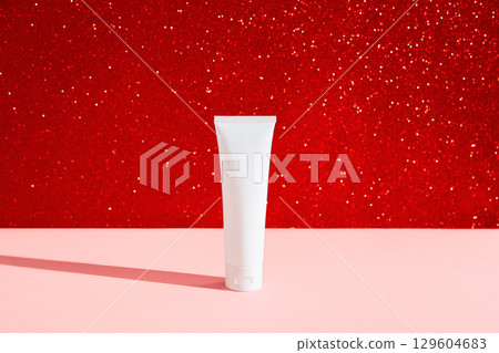 Blank white cosmetic plastic tube on red pink background. Christmas Valentines day sale concept 129604683