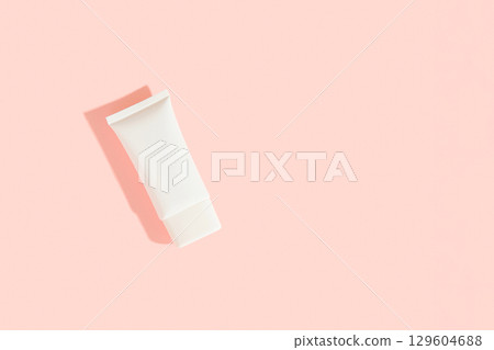 White plastic cosmetic tube on pink background. Cosmetics sale concept 129604688