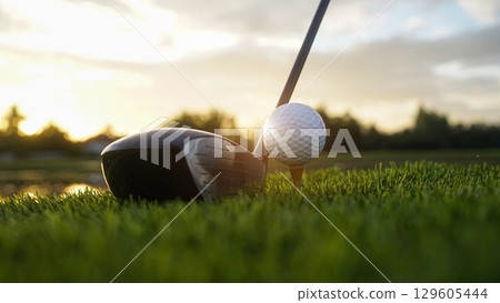 Golf clubs and balls on a green lawn in a beautiful golf course with morning sunshine. 129605444