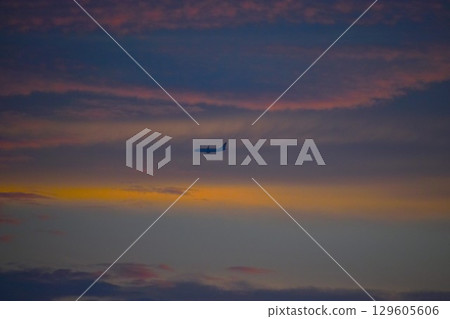 A plane flying in the afterglow 129605606