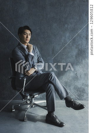 A businessman sitting in a chair 129605812