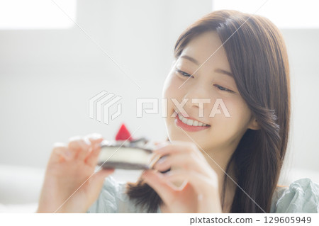 A young woman eating a cake 129605949