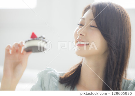 A young woman eating a cake 129605950