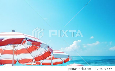 Colorful red and white striped umbrellas lined up on the beach, creating a vibrant summer vacation atmosphere 129607536