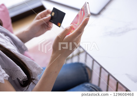 The hands of a Japanese woman shopping online on a smartphone The hands of a Japanese woman shopping online on a smartphone 129608468