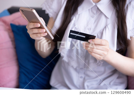 The hands of a Japanese woman shopping online on a smartphone The hands of a Japanese woman shopping online on a smartphone 129608490