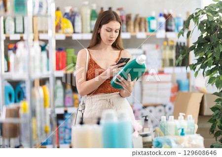 Girl client choose and scanning QR code on package liquid detergent 129608646