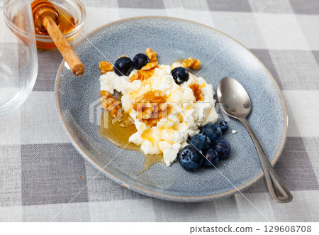 Farm cottage cheese filled with large amount of honey with walnut and blueberry. Farm cottage cheese filled with large amount of honey with walnut and blueberry. 129608708