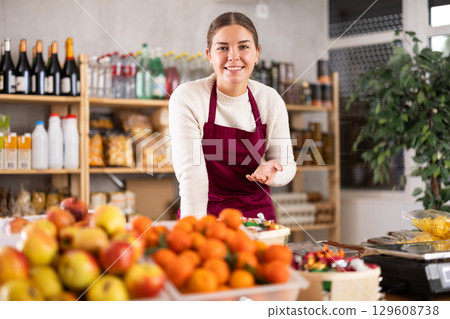 Portrait of female seller in an apron behind the counter of grocery store 129608738