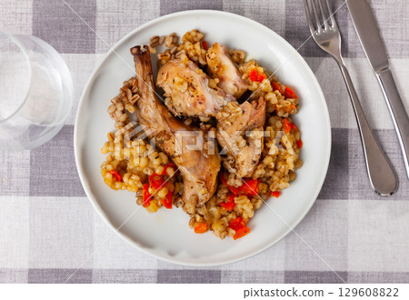 Traditional pearl barley porridge with stewed vegetables and fried rabbit on plate Traditional pearl barley porridge with stewed vegetables and fried rabbit on plate 129608822