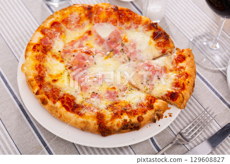 Delicious pizza with prosciutto 129608827