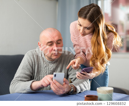 Married couple understand the settings of a mobile phone Married couple understand the settings of a mobile phone 129608832