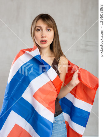 Young sad woman wrapped in Norway flag 129608868