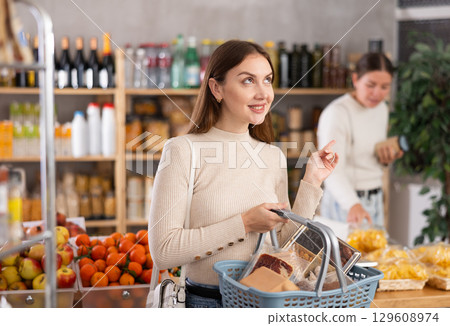 Young woman choosing groceries in the supermarket 129608974