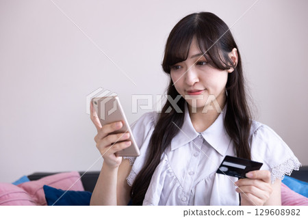 A young Japanese woman enjoying online shopping on her smartphone 129608982
