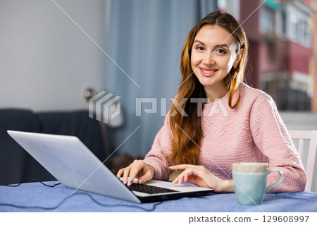 Portrait of a young woman working on a laptop Portrait of a young woman working on a laptop 129608997