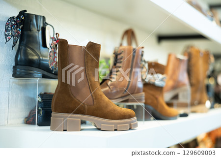 On brightly lit white shelves of store there are various variants of women shoes On brightly lit white shelves of store there are various variants of women shoes 129609003