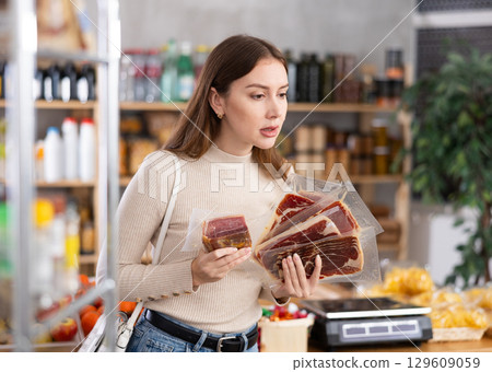 Young woman choosing jamon in grocery store Young woman choosing jamon in grocery store 129609059