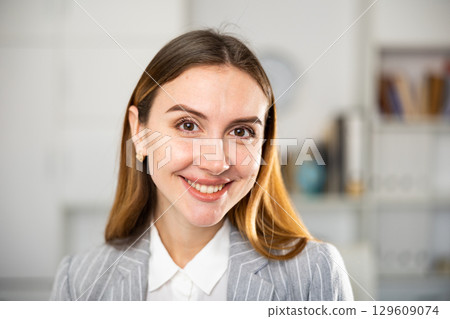 Portrait of positive smiling businesswoman in suit 129609074