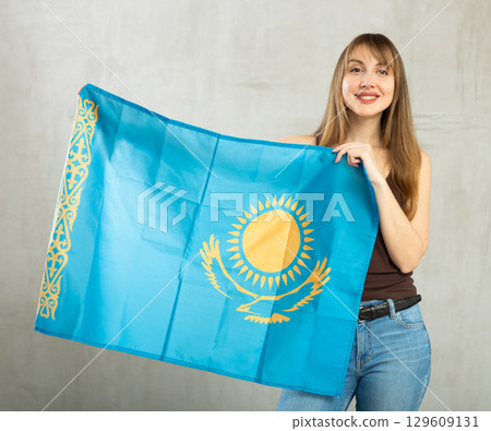 Young cheerful woman holding Kazakhstan flag 129609131