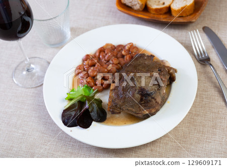 Baked pork cheek with stewed pinto beans and greens Baked pork cheek with stewed pinto beans and greens 129609171